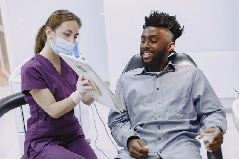A dentist going over an X-ray with a relaxed patient in the dental chair